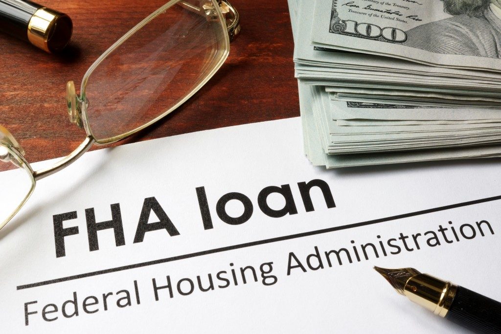 a fha loan document with a fountain pen and dollars on top of it
