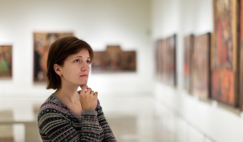 Woman looking at pictures in art gallery
