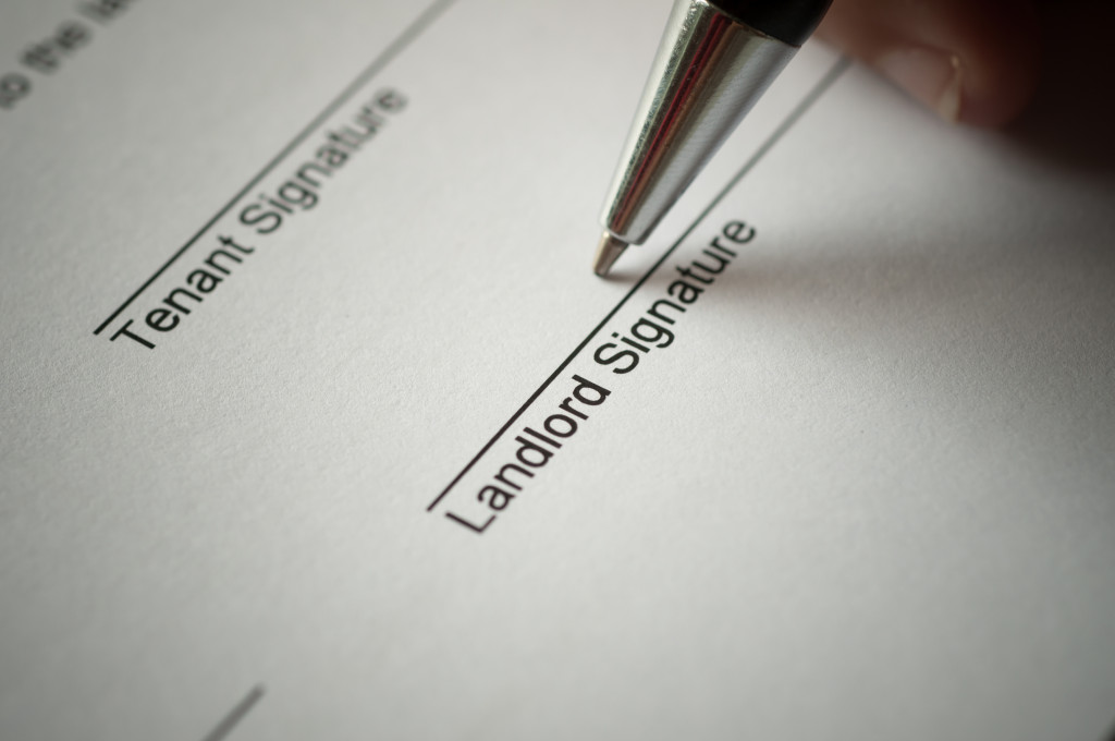 A pen on the line of the landlord signature on a rental agreement form