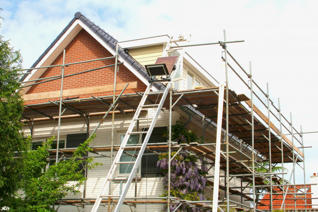 a house getting renovated with scaffolding and ladder